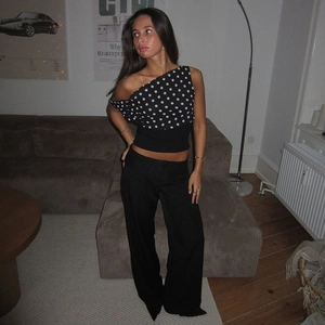 Polka dot one-shoulder cropped top paired with black high-waisted wide-leg trousers