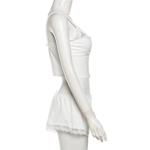 Détail d'ensemble de lingerie blanc avec broderie florale rose et bordure en dentelle