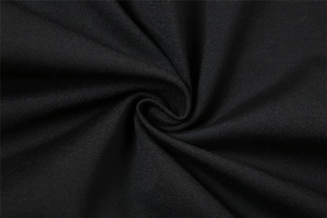 Macro shot of black twill fabric showing detailed texture and soft draped folds on top