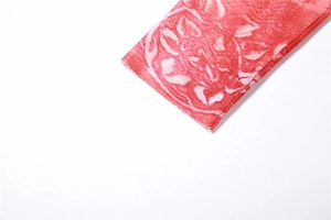 Detailansicht aus halbtransparentem Netzstoff mit rot-weißem abstraktem Blumenprint