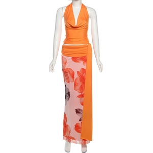 Detail of orange halter top with draped neckline and floral print maxi skirt set