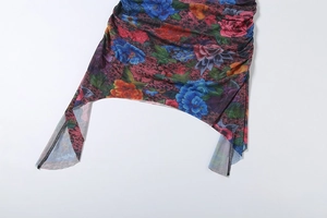Close-up of ruched side detail and asymmetric hem on floral bodycon dress