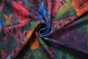 Close-up of pleated floral mesh fabric with vibrant digital print and soft texture