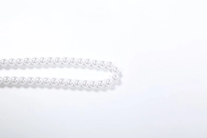 Detailansicht weißer runder Perlen mit glänzendem Finish auf einem minimalistischen Set