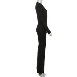 Detail view of black V-neck long sleeve jumpsuit with waist ruching on mannequin