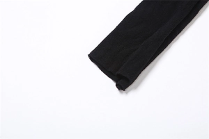 Détail du tissu en maille noire montrant une texture fine et des bords de l'ourlet cousus