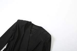 Detail of the deep V-neckline and pleated shoulder seams on a black slim fit jumpsuit