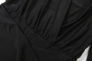 Detail of elegant black deep V-neckline with pleated fabric texture and slim fit design