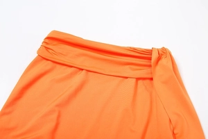 Detail of orange skirt waist with multi-layered pleats and side decorative ties