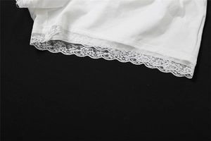 Gros plan sur un tissu en maille blanc avec une bordure en dentelle fleurie délicate