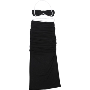 Detail eines schwarzen Zweiteilers mit perlenbesetztem Neckholder-Top und Faltenrock