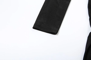 Close-up of the fine knit fabric texture and sleeve stitching on black long sleeve romper