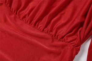 Detalle del vestido rojo de punto que muestra el diseño plisado y la costura de cintura alta