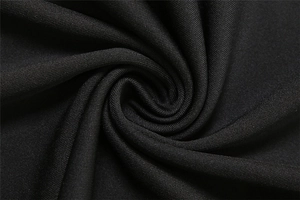 Macro detail of the fine-textured black stretch fabric showing its soft drapes and texture