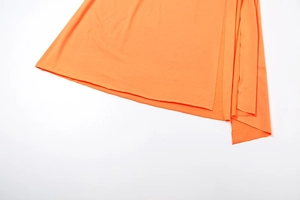 Close-up of bright orange skirt hem showing fine fabric texture and neat stitching