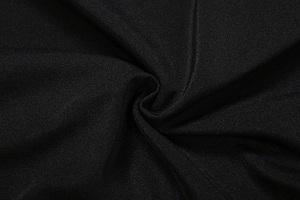 Macro detail of high-quality black jersey fabric texture with elegant pleated folds