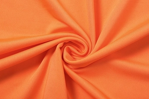 Detail shot of bright orange twill fabric showing soft texture and elastic weave pattern