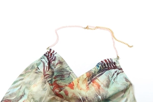 Détail de la robe dos nu avec imprimé artistique et bretelles chaîne asymétriques