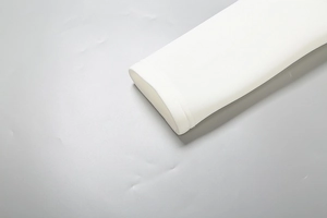 Détail d'une manche de robe blanche avec couture double aiguille précise et ourlet de qualité