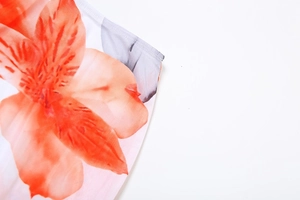 Detailed macro view of vibrant orange floral print fabric with fine stitching quality