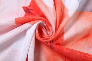 Detailed macro view of white mesh fabric featuring vibrant red floral print patterns