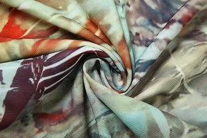 Détail macro d'un tissu à imprimé floral abstrait aux textures rouges et vertes