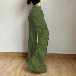 Detailed side view of high-waist olive green trousers with drawstring ruched leg texture