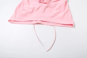 Macro detail of pink knitted top hem featuring drawstring closure and precise stitching