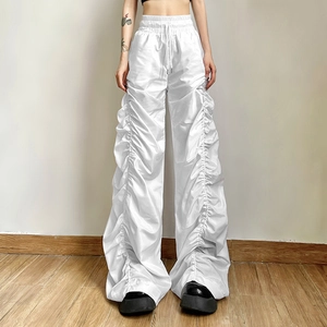 Macro shot of white high-waist wide-leg trousers with pleated details and drawstring waist