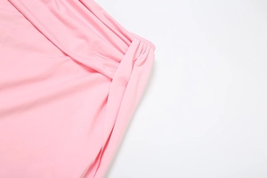 Detail view of pink elastic fabric featuring gathered knot and texture on the skirt
