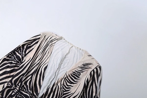 Detail of off-shoulder neckline with black and cream abstract zebra pattern texture