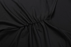 Macro view of black ruched fabric detailing on a backless bodycon jumpsuit