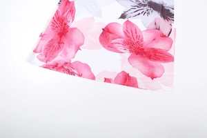 Close-up of pink and grey lily floral print pattern on soft white fabric detail