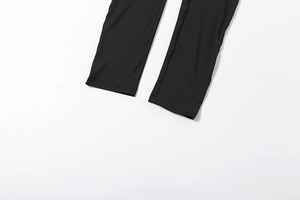 Close-up of black tight jumpsuit leg cuff with high-quality double-needle stitching
