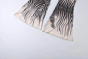 Detailed view of zebra print flare leg trousers showing the wide bell bottom hem style