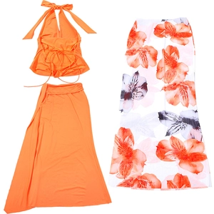 Three-piece set detail with orange halter top and white floral print wrap skirt