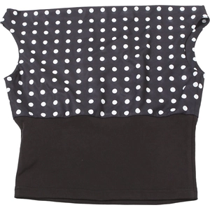 Detailed close-up of a two-tone polka dot and black sleeveless one-shoulder crop top