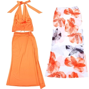 Detail of vibrant orange halter top set and tropical floral print maxi skirt for beachwear