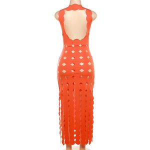 Detail view of bright orange long dress featuring cutout back design and scalloped hemline
