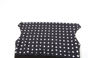Detailed view of polka dot pattern on black fabric with elegant straight neckline design