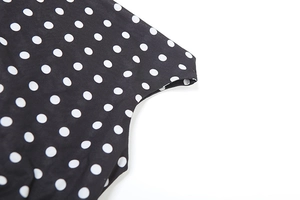 Detail shot of the black and white polka dot fabric texture on the stylish crop top