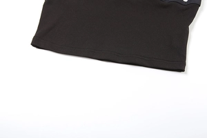 Detailed macro view of the double-stitched hem on this black knit summer crop top