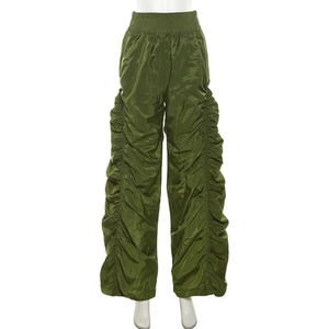 Detail of olive green wide-leg trousers featuring adjustable ruched sides and elastic waist