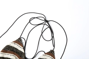 Close-up of striped knit bikini top showing texture and intricate black tie-up details