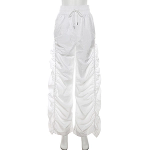 Detail of white wide-leg trousers featuring elastic drawstring waist and ruched side texture
