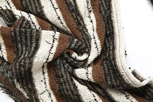 Macro view of textured knit fabric with earth tone stripes in brown and beige colors