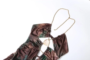Detail of marble tie-dye dress featuring a gold chain halter neck and shell accent