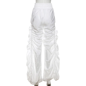 Detail of white high-waisted ruched wide-leg pants with metallic sheen finish