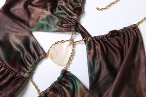 Detail of halter dress with gold chain, shell pendant and green marble print