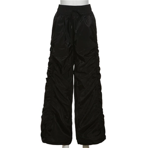 Detail view of high-waisted black ruched trousers with adjustable drawstring and satin finish